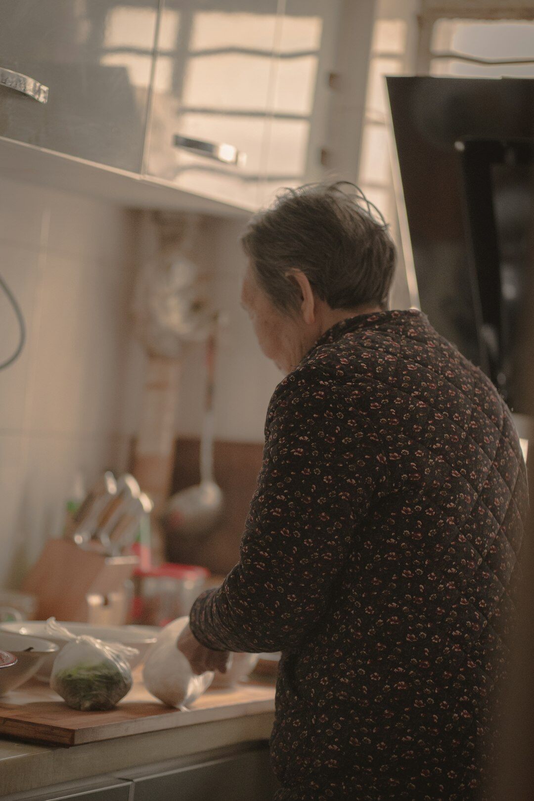 Seniors cooking together and laughing in a community kitchen